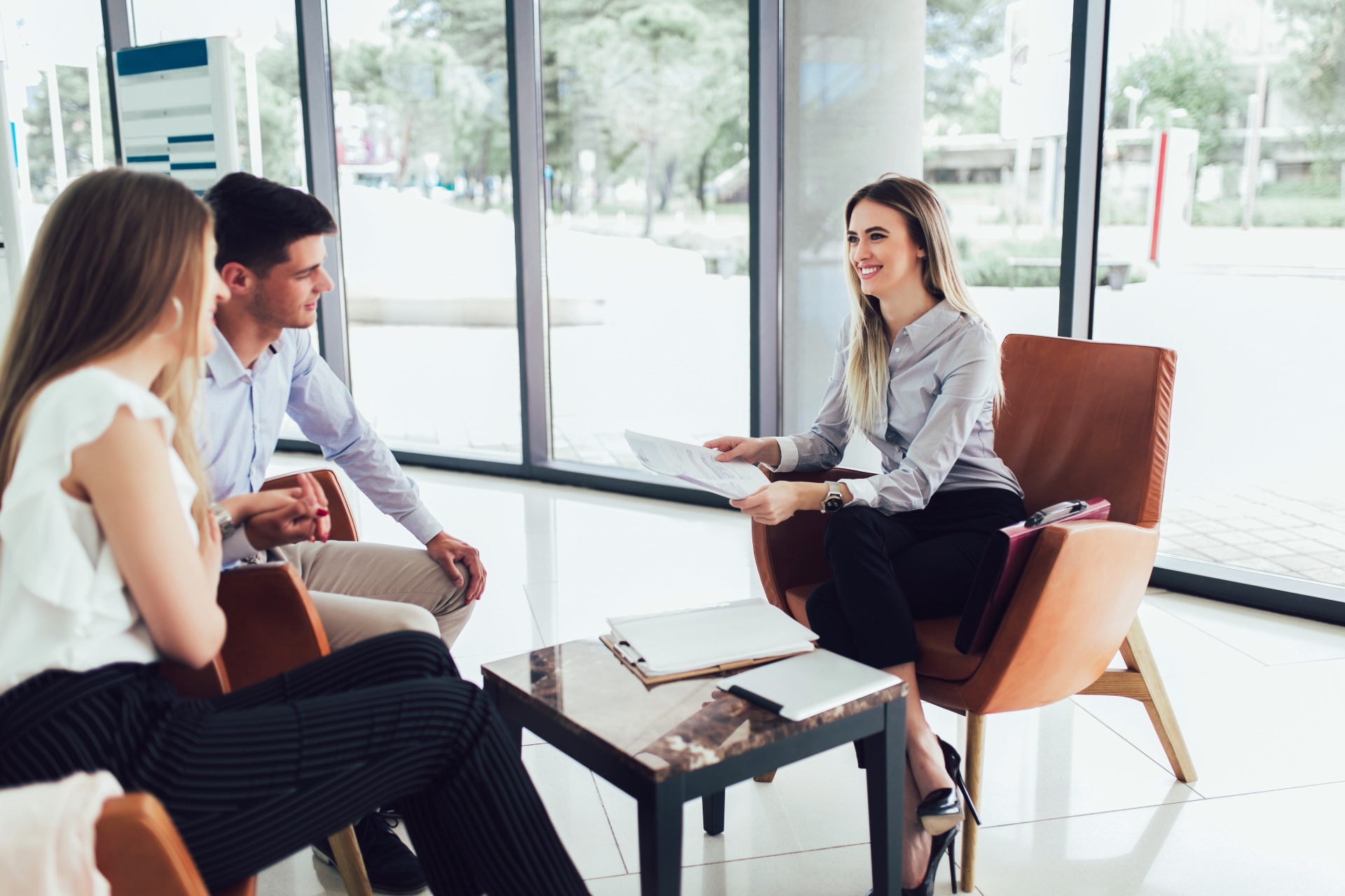 Woman talking to a couple in a professional environment