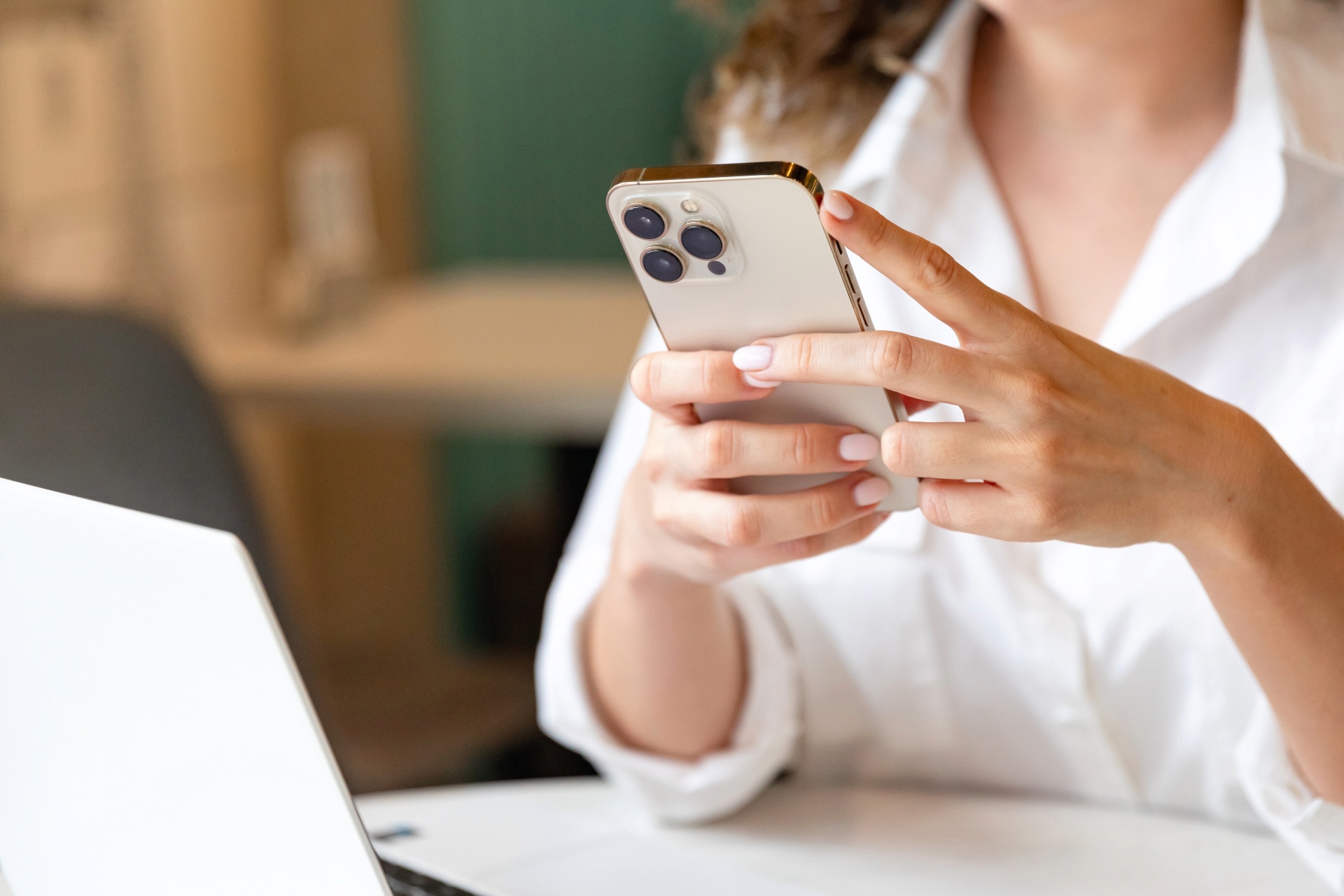 A woman on her phone in front of a computer