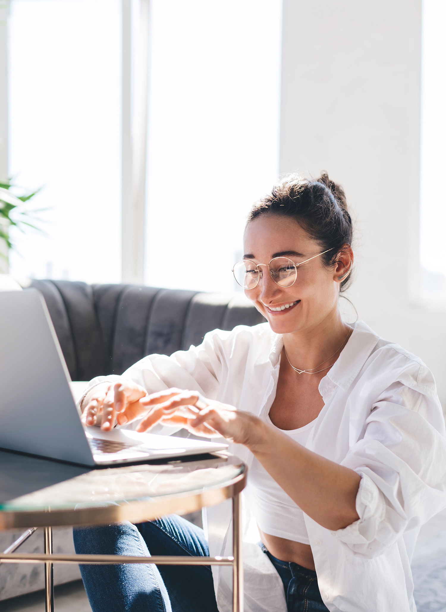 Surrogate smiling while using her laptop at home